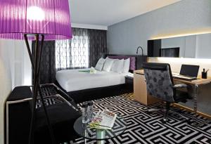 香港香港湾仔睿景酒店的酒店客房配有一张床和紫色灯