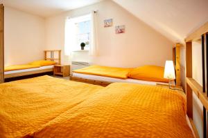 卢捷纳普德克利诺夫琴Apartmány Happy Klínovec的配有黄色床单的客房内的两张床