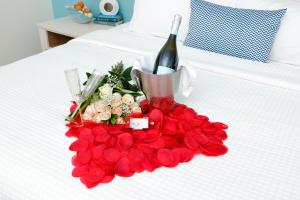 格尔夫海岸Hotel Indigo Orange Beach - Gulf Shores, an IHG Hotel的床上一束玫瑰和一瓶葡萄酒