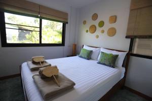 Takua PaThipwararom homestay的卧室配有白色的床和2条毛巾