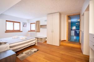 阿莱盖Dolomites Seasons的一间卧室配有一张床,一扇门通往浴室