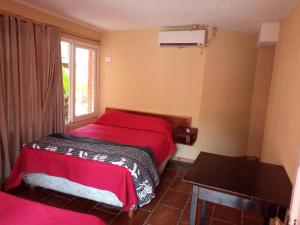 伊瓜苏港Sweet Guest House的一间卧室设有红色的床和窗户。