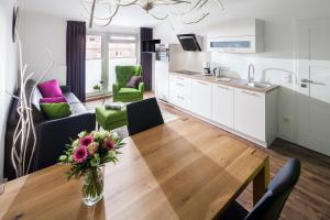于斯德Appartement Haus Bracht- direkt am Kurplatz的厨房以及带木桌和椅子的客厅。