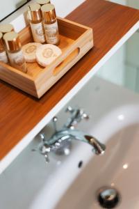 吉马良斯Apartamentos com História的浴室水槽,配有带化妆品的木制托盘