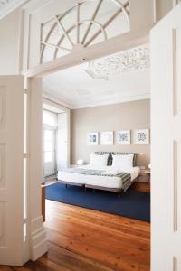 吉马良斯Apartamentos com História的一间卧室配有一张床和蓝色地毯