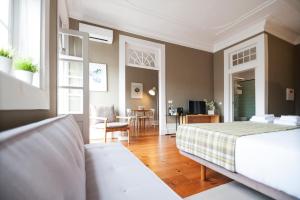 吉马良斯Apartamentos com História的一间卧室设有一张床和一间客厅。