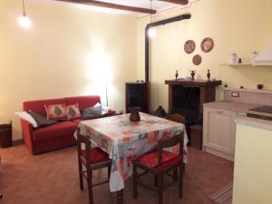 皮蒂利亚诺Relax nel tufo的客厅配有桌子和红色沙发