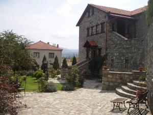 SklíthronGuesthouse Agonari的一座石头房子,设有庭院和一座建筑