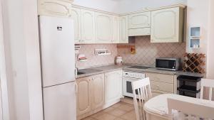 帕莱索海滩Marina Palace Paraiso的厨房配有白色橱柜和白色冰箱。