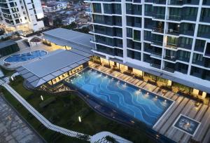 古晋Luco Apartments @ Viva City Megamall的享有带游泳池的大型建筑的顶部景色