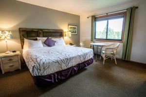 姐妹湾Open Hearth Lodge的一间卧室配有一张床、一张桌子和一个窗户。