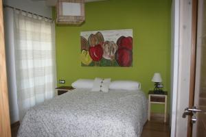 莱萨卡古尔伊多陪公寓的卧室配有一张床,墙上挂有绘画作品