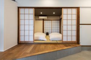 金泽Kamin Kanazawa的带玻璃门的客房内的两张床