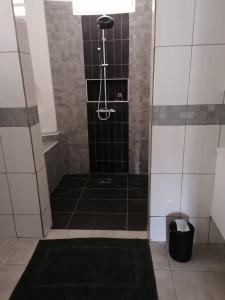 Rémire-CampLogement de 100 m carré的浴室铺有黑色和白色瓷砖,设有淋浴。