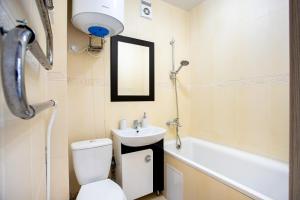 尼古拉耶夫Студия на Адмиральской的浴室配有卫生间、盥洗盆和浴缸。