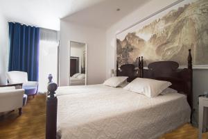 丰沙尔Vila Vicência的一间卧室配有一张大床,墙上挂着一幅大画