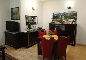 扎科帕内Apartament Radowid 15 w centrum z basenem的一间带桌子和红色椅子的用餐室