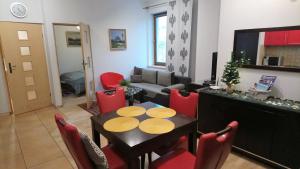 扎科帕内Apartament Radowid 15 w centrum z basenem的客厅配有桌子和红色椅子