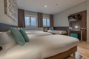 阿姆斯特丹Hotel Damsquare的酒店客房设有三张床和电视。