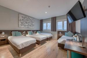 阿姆斯特丹Hotel Damsquare的酒店客房设有两张床和一台平面电视。