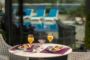 罗戈兹尼察Boutique Hotel Life的一张桌子,上面放着两杯葡萄酒和食物