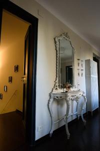 热那亚B&B Piccoli Leoni的墙上的白色梳妆台和镜子