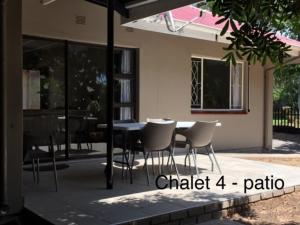 帕拉博鲁瓦Impala Chalets的房屋前设有带桌椅的天井。