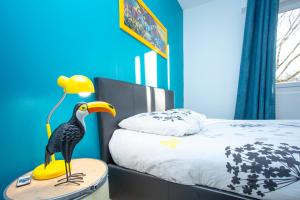 洛里昂SMILE APPARTS - Appartements - Au coeur de Lorient - Au calme - Tout Confort的卧室,床边桌子上放鸟玩具