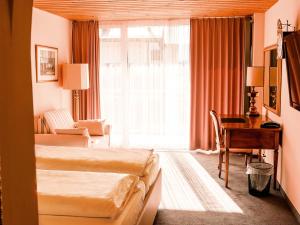 弗利姆斯Hillsite Smart Hotel Flims的酒店客房配有两张床和一张书桌