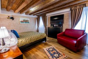 威尼斯EGO' Residence Venice的一间卧室配有一张床和一张红色椅子