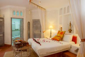 迪亚尼海滩玛吉海滩精品酒店的一间卧室配有一张带鲜花的大床