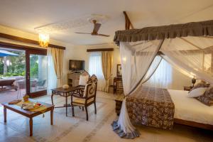迪亚尼海滩玛吉海滩精品酒店的一间带天蓬床的卧室和一间客厅