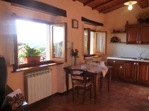 普拉托韦基奥MAGNOLIA TUSCANY HOUSE WITH POOL Agriturismo Poppiena的厨房配有桌子和大窗户