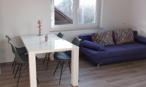 戈雷尼斯卡地区采尔克列Apartmaji Pika的客厅配有白色桌子和蓝色沙发