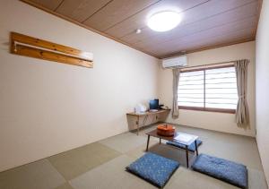 阿扎格瓦kawagutiko station inn / Vacation STAY 63722的客厅配有桌子和窗户