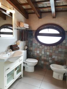 麦地那西多尼亚Posada Alegria的一间带卫生间、水槽和窗户的浴室