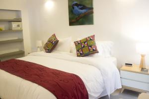 佩雷拉Cotinga Hotel Spa的卧室配有一张带红色毯子的白色床