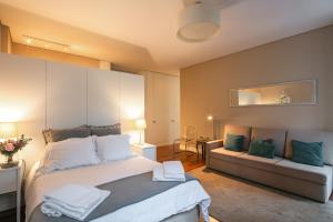 波尔图Cardosas Charming Apartment with Balconies的一间卧室配有一张大床和一张沙发