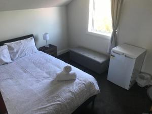 基督城Sandy Feet Lodge的卧室配有白色的床和窗户。
