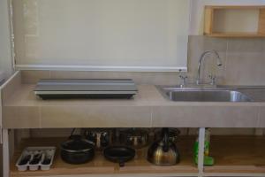 别霍港Jaguar Inn Bungalows的厨房配有水槽以及带锅碗瓢盆的台面。