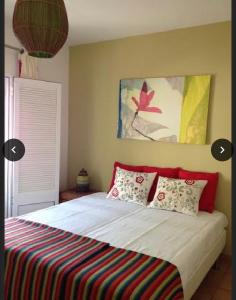 马林堡Casa de férias na Praia Verde Casa de Charme的一间卧室配有一张带彩色条纹毯子的床