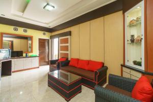 BebekoRedDoorz Syariah @ Mora Garden Bungo的带沙发和红色枕头的客厅