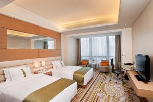天津天津海河假日酒店的酒店客房设有两张床和电视。