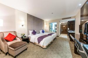 武汉武汉帝盛酒店的一间卧室配有一张大床和一把椅子