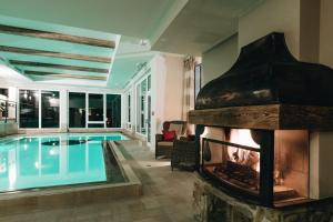瑟尔DER GREIL - Wein & Gourmethotel的游泳池旁设有壁炉的游泳池