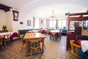 毛特恩多夫维特加塞酒店的餐厅设有桌椅和墙上的时钟