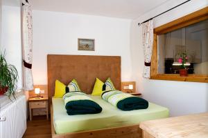 索普拉布扎诺Gasthaus Babsi的一间卧室配有一张带黄色和绿色枕头的床