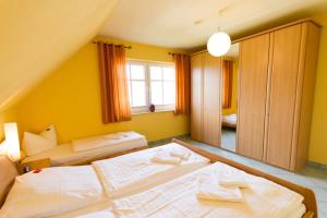 岑平Ferienhaus Iris的黄色墙壁客房的两张床