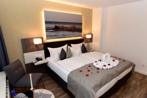 韦斯特兰塞尔特尔霍夫酒店的酒店客房设有一张带玫瑰花的大床