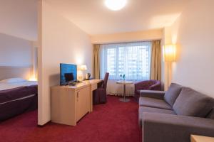 里加Riga Islande Hotel with FREE Parking的酒店客房配有床、沙发和电视。